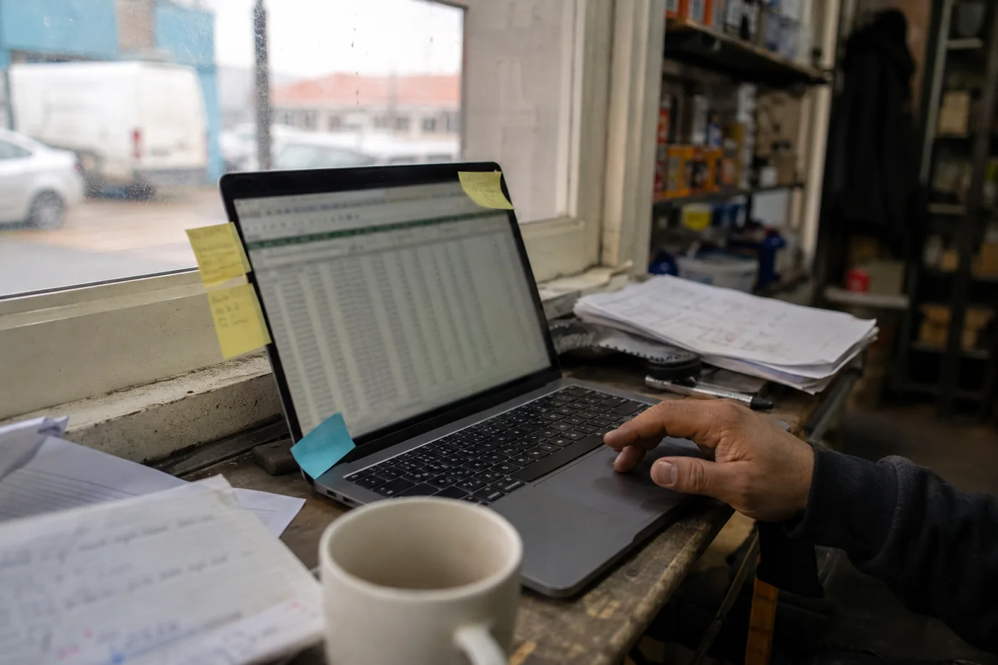 Un notebook con una planilla abierta entre papeles y notas pegadas